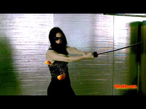 Slowmotion: Frau durchsäbelt Orange in der Luft