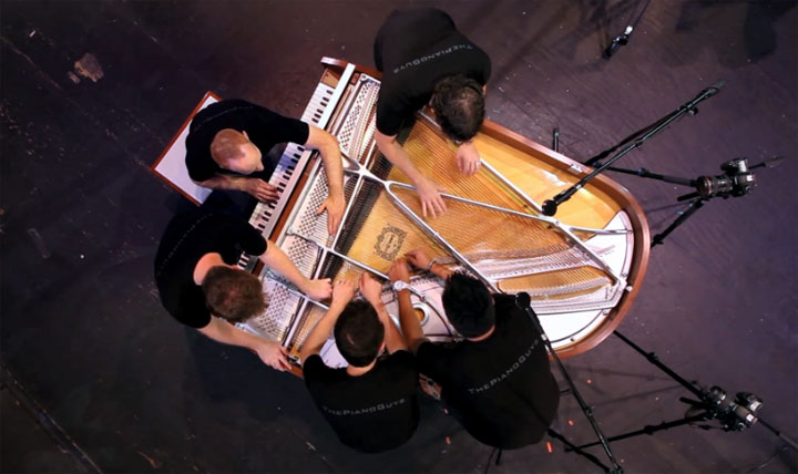 5 Männer spielen an einem Klavier