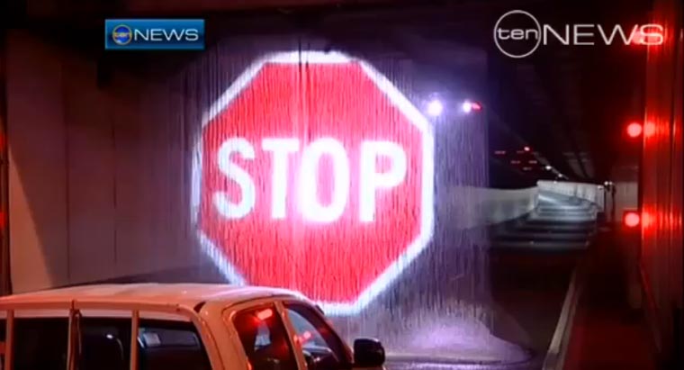 Stopschildprojektion auf Wasserwand stoppt zu hohen LKW vor Tunneleinfahrt