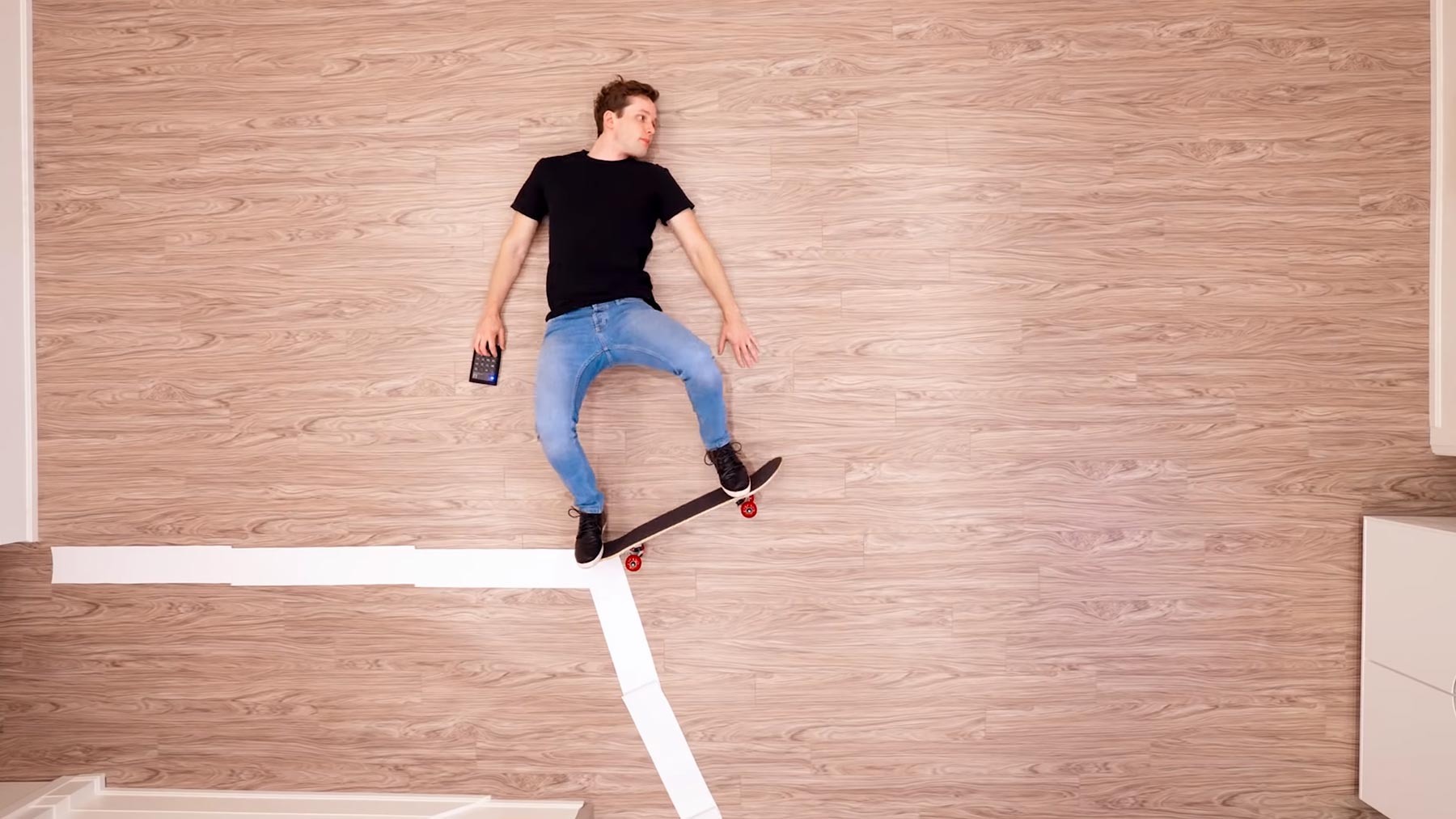Kevin Parry fährt auf dem Boden liegend Skateboard