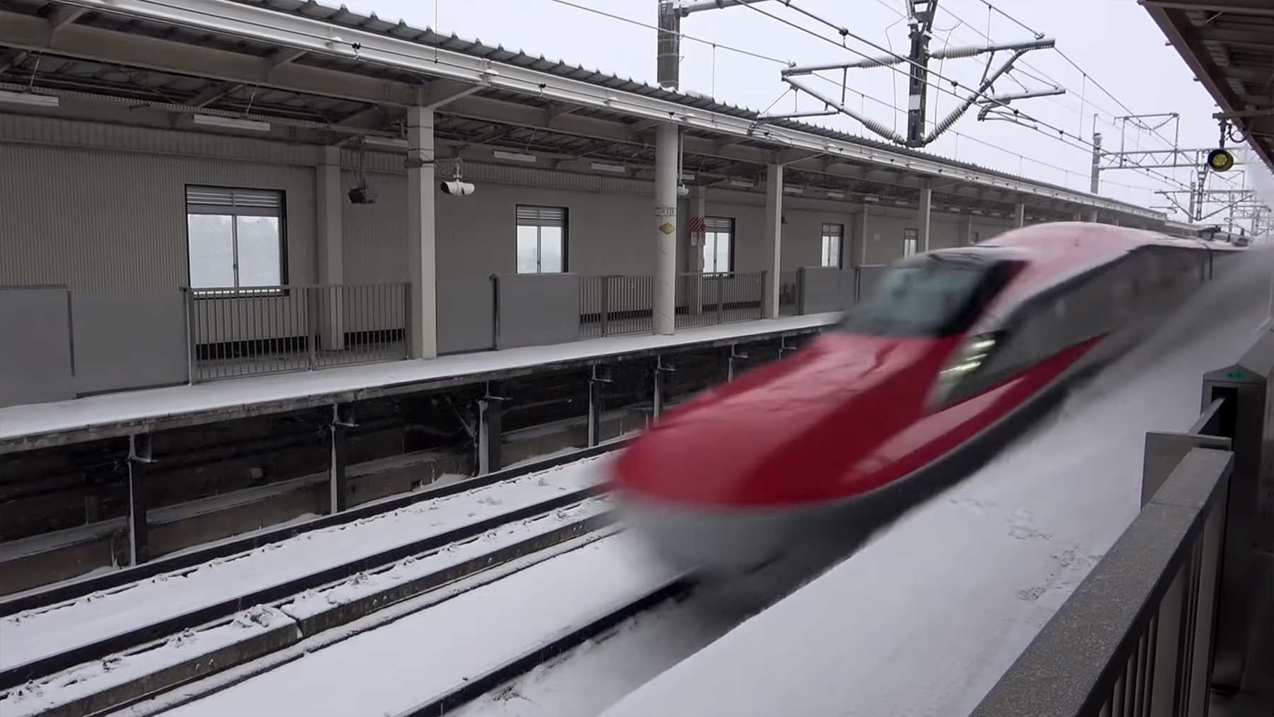Shinkansen-Zug rast durch Schnee an Station